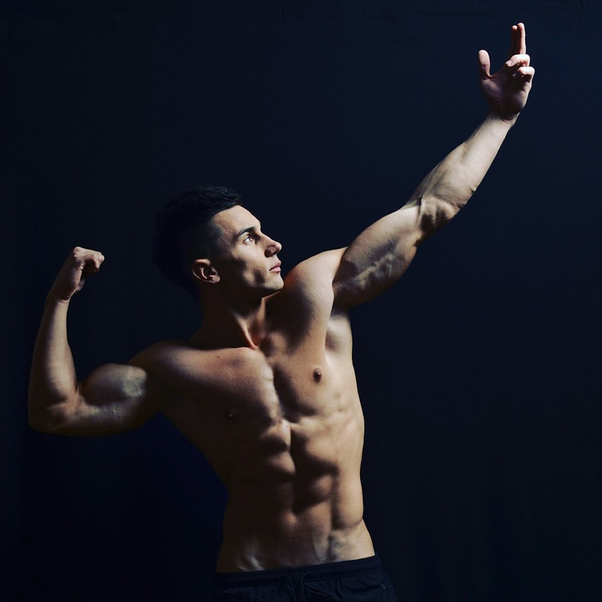 Man die zijn spieren flext in bodybuilding pose