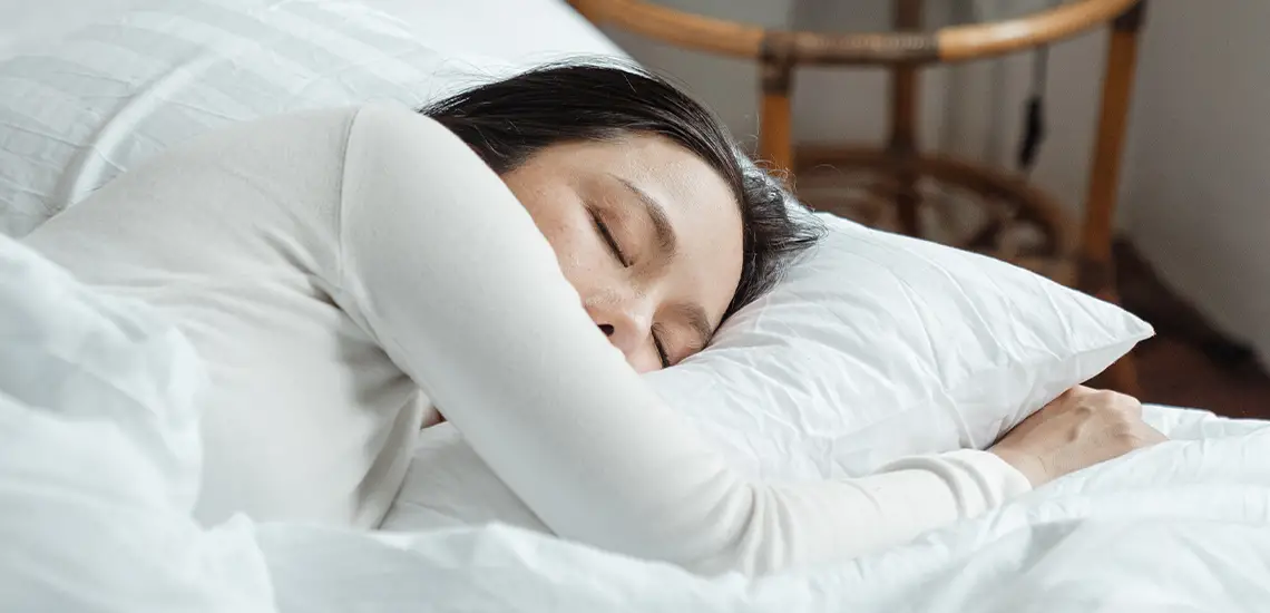 Vrouw slaapt heerlijk in bed dankzij Droomsap